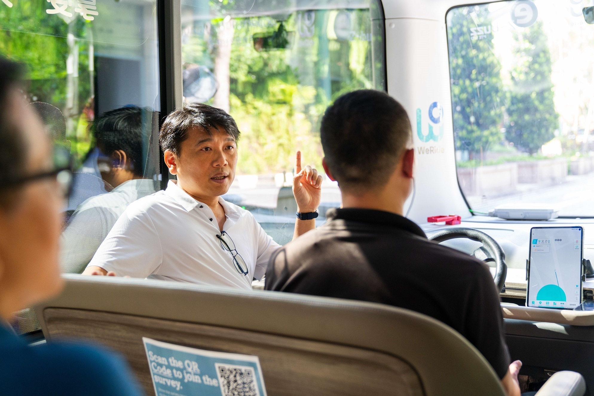 Sebastian talking to his colleague in a WeRide bus